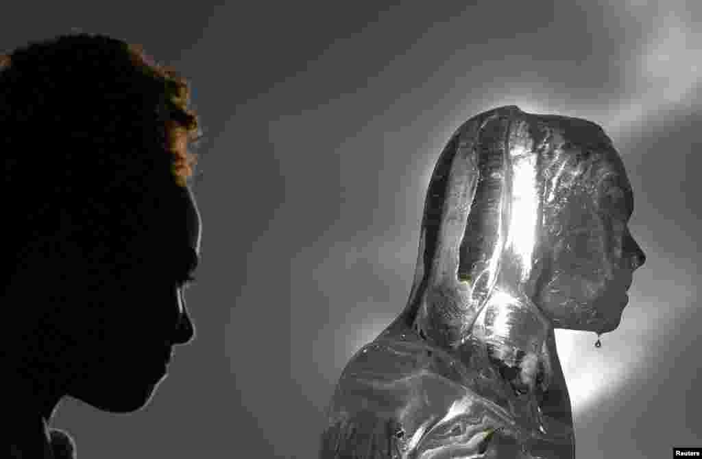 Water drips from an ice sculpture depicting a woman walking to collect water, as environmental and public health campaign group WaterAid highlights the threat posed globally by climate change to healthy water supplies, in London.