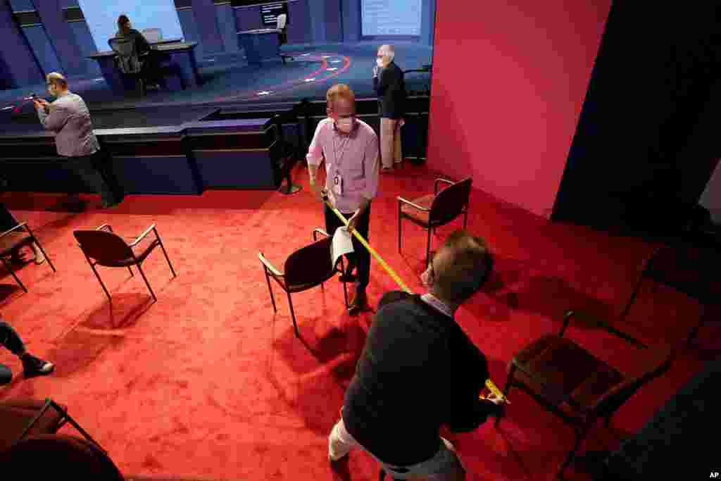 Members of the Commission on Presidential Debates use a measuring tape to ensure seats are socially distant as preparations take place for the vice presidential debate at the University of Utah in Salt Lake City.