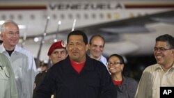 Venezuela's President Hugo Chavez (C) gestures after his arrival from Cuba, at Simon Bolivar International Airport in Caracas, July 23, 2011.