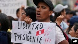 Seorang pendukung Presiden Peru yang terguling Pedro Castillo memegang poster di luar markas polisi tempat Castillo ditahan, di pinggiran Lima, Peru, Kamis, 11 Desember 2018. 15, 2022. (Foto: AP)