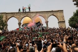 Palestinians react at the compound that houses Al-Aqsa Mosque, known to Muslims as Noble Sanctuary and to Jews as Temple Mount, in Jerusalem's Old City, May 21, 2021.