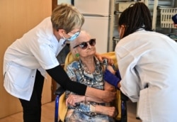 A doctor administers a dose of Pfizer-BioNtech coronavirus disease (Covid-19) vaccine to an old woman on Jan. 4, 2020 at the Antonin Balmes gerontology center in Montpellier in the south of France.