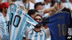 A fan holds up jerseys with the name of Argentina's Lionel Messi before a match between France and Argentina, at the Kazan Arena in Kazan, Russia, Saturday, June 30, 2018. (AP Photo/Thanassis Stavrakis)