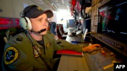 Royal Australian Air Force Airborne Electronics Analyst Flight Sergeant Tom Stewart from 10 Squadron watching a radar screen for signs of debris on board an AP-3C Orion over the Southern Indian Ocean during the search for missing Malaysian Airlines flight