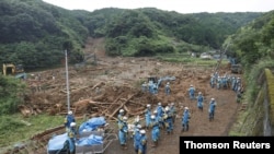 Police officers search for missing people at a landslide site caused by a heavy rain in Tsunagi town, Kumamoto prefecture, Japan