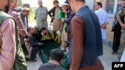 Relatives and others gather around the coffin of a soldier who died in heavy fighting between Afghan security and Taliban forces, outside a hospital in Takhar province, Oct. 21, 2020. Nearly a dozen chidren were killed in an airstrike a day later.