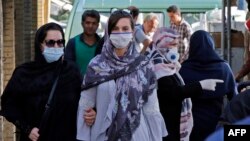 Iranians, some wearing face masks, walk at a market in the capital Tehran as the spread of novel coronavirus has accelerated again with over 3,000 new cases for a third consecutive day, June 3, 2020.