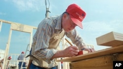 Mantan Presiden Jimmy Carter menandai papan yang akan dipotong saat ia bekerja dengan proyek Habitat for Humanity di Charlotte, N.C., 27 Juli 1987. (Mark Humphrey/AP)