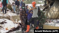 Anggota tim penyelamat membawa kantong jenazah berisi korban meninggal di Desa Klatanlo, Kabupaten Flores Timur, Nusa Tenggara Timur, 4 November 2024, pascaerupsi Gunung Lewotobi Laki-Laki. (Foto: Arnold Welianto/AFP)