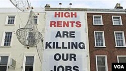 Este cartel en Dublín, Irlanda, critica como el alto costo de la vivienda está afectando los trabajos.