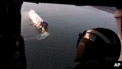 8일 미국 조지아주 브런즈윅항 외곽 해상에서 전도돼 옆으로 기운 현대글로비스 소속 자동차 운반선 골든레이호가 헬기 문 사이로 보인다. 