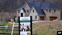 FILE - In this Feb. 27, 2017 photo, real estate signs mark the lots near one of the new homes for sale in a development for new homes in Cranberry Township, Butler County, Pa. 
