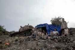 Fighters from a militia known as the Security Belt, funded and armed by the United Arab Emirates, take a break, Aug. 5, 2019, to chew Qat for its stimulating effects, at the Gabhet Hajr frontline with Houthi rebels, in Yemen's Dhale province.