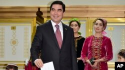 Turkmenistan President Gurbanguly Berdimuhamedov, center, smiles as he casts his ballot at a polling station in Ashgabat, Turkmenistan, Sunday, Feb. 12, 2017. (AP Photo, Alexander Vershinin)