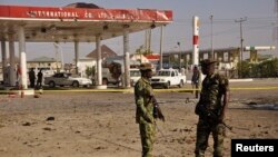 Members of the military stand at the scene of an explosion near a petrol station in Kano, Nigeria, Nov. 15, 2014. 