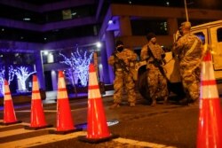 FILE - National Guard personnel and police secure a street near the Capitol, Jan. 17, 2021.