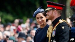 FILE - Britain's Meghan, the Duchess of Sussex and Prince Harry ride in a carriage to attend the annual Trooping the Colour Ceremony in London, June 8, 2019. 