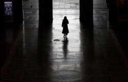 A lonely passenger leaves Milan main train station, Italy, March 9, 2020. Italy took a page from China's playbook Sunday, attempting to lock down 16 million people for nearly a month to halt the coronavirus.