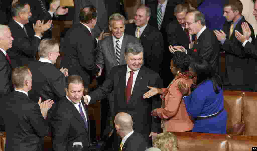 President Petro Poroshenko, escorted by House Majority Leader Kevin McCarthy, R-Calif., is welcomed by U.S. lawmakers as he arrives to address a joint meeting of Congress, at the Capitol in Washington, Sept. 18, 2014. 