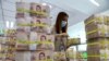 FILE - A bank employee gathers Thai baht notes at a Kasikornbank in Bangkok, Thailand, Jan. 26, 2023.