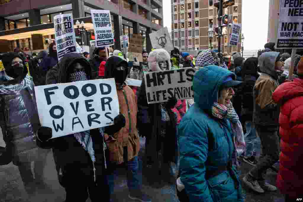 Demonstrators chant and hold signs as they march through the streets to protest against Donald Trump on the day of his inauguration as the 47th U.S. president in Boston, Massachusetts, Jan. 20, 2025. 