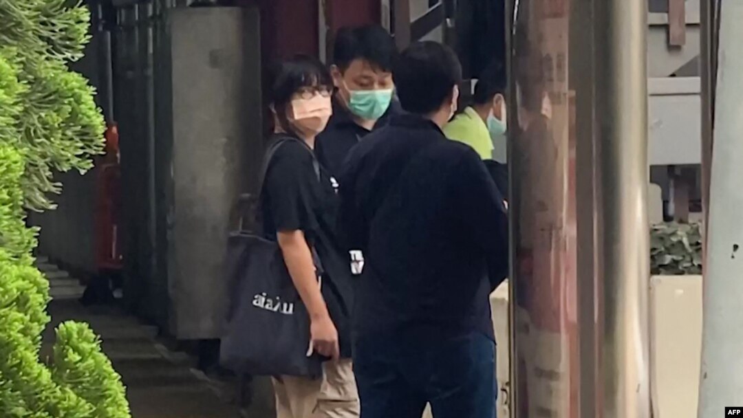This video frame grab taken from AFPTV footage shows Chow Hang Tung, left, leader of the Hong Kong Alliance in Support of Patriotic Democratic Movements of China, being led away by police after being detained in Hong Kong on June 4, 2021.