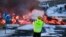 A road agency worker takes a picture as molten lava flows over the road leading to the tourist destination Blue Lagoon spa near Grindavik, Iceland, on Feb. 8, 2023.