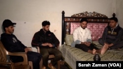 In this image taken from video, Amir Ali, second from right, rests as friends look at his injured foot on Feb. 3, 2025, at his home in Gujranwala district, Pakistan. Despite Ali’s horrific experience, his friends say they want to try getting to Europe.