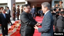 FILE - South Korean President Moon Jae-in shakes hands with North Korean leader Kim Jong Un during their summit at the truce village of Panmunjom, North Korea, May 27, 2018. (Handout photo from KCNA via Reuters)