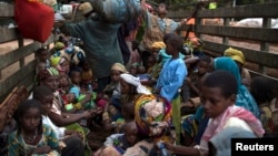 FILE - People, consisting mostly of women and children, sit at the back of a truck as the prepare to flee sectarian violence in a convoy escorted by African Union (AU) peacekeepers towards the border with Cameroon, in the town of Bouar, west of the Central African Republic.