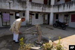Farmer Ramkrishan Malawat takes out water from a hand pump which is on its last leg in Bawal, in the Indian state of Haryana. “There is so much construction around here and when it rains now, the water just flows away," he said. (AP Photo/Manish Swarup)