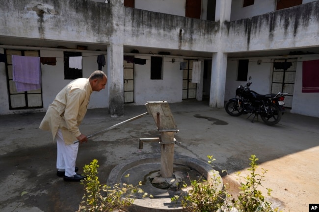 Farmer Ramkrishan Malawat takes out water from a hand pump which is on its last leg in Bawal, in the Indian state of Haryana. There is so much construction around here and when it rains now, the water just flows away," he said. (AP Photo/Manish Swarup)