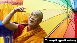 Pemimpin spiritual Tibet, Dalai Lama, melambai kepada orang banyak saat peresmian kuil Thupten Shedrub Ling di pinggiran Huy, Belgia, 29 Mei 2006. (Foto: REUTERS/Thierry Roge)