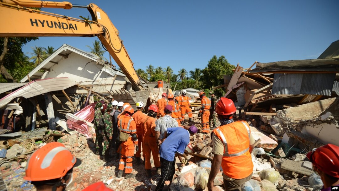 Para petugas penyelamat mencari korban-korban di bawah puing-puing di Desa Sigar Penjalin, utara Lombok, di Nusa Tenggara Barat, 8 Agustus 2018, tiga hari setelah gempa kuat mengguncang wilayah tersebut.