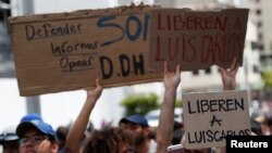 Personas con carteles que dicen "liberen a Luis Carlos" asisten a una conferencia de prensa de Naky Soto, esposa del periodista venezolano Luis Carlos Díaz, detenido por más de 24 horas por agentes en marzo del 2019. 