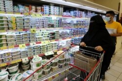 FILE - A Saudi woman looks at the dairy products in a supermarket, after Saudi Arabia's retail stores urged customers to boycott Turkish products, in Riyadh, Saudi Arabia, Oct. 18, 2020.