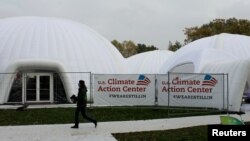 A woman walks past a tent, set up by U.S. groups opposed to U.S. President Donald Trump climate policies, on the sidelines of U.N. COP-23 climate conference in Bonn, Germany, Nov. 9, 2017. According to the State Department, the U.S. is represented at the talks.