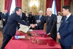 Vincenzo Amendola, left, shakes hands with Italian President Sergio Mattarella as he is sworn in as Italy's European affairs minister during a ceremony in Rome, Sept. 5, 2019.