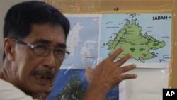 Abraham Idjirani, spokesman for the Sultanate of Sulu, points at a map of Borneo's eastern Sabah state as he talks to reporters in suburban Taguig, south of Manila, Philippines, March 5, 2013.