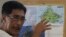 Abraham Idjirani, spokesman for the Sultanate of Sulu, points at a map of Borneo's eastern Sabah state as he talks to reporters in suburban Taguig, south of Manila, Philippines, March 5, 2013.
