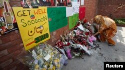 A supporter of Imran Khan, Pakistani cricketer-turned-politician and chairman of political party Pakistan Tehreek-e-Insaf (PTI), lays flowers outside Shaukat Khanum Cancer Hospital to pray for his quick recovery in Lahore May 8, 2013. 