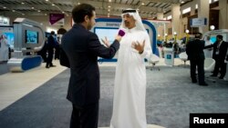 Saudi Aramco Chief Executive Officer Khalid al-Falih (R) speaks to a media member at the company's booth during Petrotech 2014 (a petrochemicals conference) at the Bahrain International Exhibition Center in Manama, May 19, 2014.