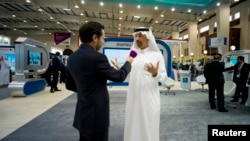 FILE - Saudi Aramco Chief Executive Officer Khalid al-Falih, right, at the company's booth during Petrotech 2014, Bahrain International Exhibition Center, Manama, May 19, 2014.