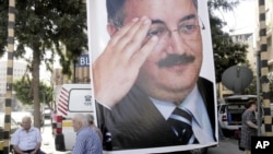 A memorial poster of Brig. Gen. Wissam al-Hassan, who was assassinated Friday, hangs near the spot Friday's car bomb attack that killed Al-Hassan, in the Achrafiye district of Beirut, Lebanon, October 23, 2012.