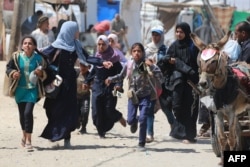 Warga Palestina bergegas meninggalkan tempat mereka saat Israel melakukan pemboman di kawasan Rafah di Jalur Gaza selatan, 19 Juni 2024. (Bashar TALEB / AFP)