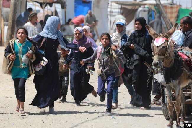 Warga Palestina bergegas meninggalkan tempat mereka saat Israel melakukan pemboman di kawasan Rafah di Jalur Gaza selatan, 19 Juni 2024. (Bashar TALEB / AFP)