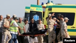 Une secouriste porte un corps dans une ambulance après qu'un bateau se soit renversé au large des côtes égyptiennes, à Al-Beheira, Egypte, le 22 septembre 2016.