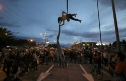 A man performs hanging from a bridge during an anti-government protest in Bogota, Colombia, Nov. 27, 2019.