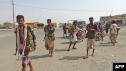 Yemeni fighters loyal to the Saudi-backed Yemeni president walk down a street in the town of Khokha in the western province of Hodeidah on Dec. 18, 2018. 