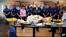 El presidente Trump y la primera dama, Melania Trump (blusa rosada) celebran Thanksgiving con miembros de la Guardia Costera en Florida.